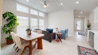 Located at 1009 Big Constellation Way in San Marcos, TX, this thoughtfully designed single-story residence offers a comfortable and functional layout across a well-utilized floor plan. The bright, open living and dining area is anchored by tall windows that flood the space with natural light, complemented by a ceiling fan, recessed lighting, and vaulted ceilings that lend an airy, spacious feel. The kitchen is outfitted with crisp white shaker cabinetry, white quartz countertops, a subway tile backsplash, and a full suite of stainless steel appliances, including a dishwasher, range, over-the-range microwave, and refrigerator. A window above the sink adds additional natural light to the space. The generously sized primary bedroom features vaulted ceilings, soft carpeting, multiple windows with outdoor views, and ample room for a large bed and furnishings. The versatile office provides a flexible secondary space with natural light and neutral finishes, suitable for a variety of uses. The bathroom is finished with tile flooring, a glass-enclosed walk-in shower, a vanity with storage cabinetry, and a small window for ventilation. Crown molding and consistent neutral tones throughout contribute to the cohesive, clean aesthetic of this well-maintained residence.