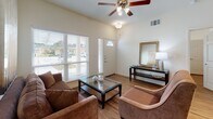 Located at 905 E Main St in Allen, Texas, this single-story residence offers a thoughtfully designed layout with consistent, modern finishes throughout. The living area greets residents with soaring ceilings, hardwood-style flooring, and large windows fitted with blinds that allow abundant natural light while providing exterior views of the surrounding neighborhood. A ceiling fan and an inviting entry door with a transom window contribute to the room's airy, welcoming atmosphere.

The kitchen is well-equipped with rich, dark espresso cabinetry, granite countertops, and a full suite of stainless steel appliances, including a side-by-side refrigerator with an ice and water dispenser, an electric range, and a built-in microwave. An in-unit stacked washer and dryer are conveniently situated nearby. The galley-style layout maximizes counter and storage space efficiently.

The bedrooms feature hardwood-style flooring, ceiling fans, and ample natural light. One bedroom includes direct access to a walk-in closet, while another opens to a private bathroom. The bathrooms are finished with large-format stone-look tile in the walk-in glass-enclosed showers, granite vanity surfaces, dark cabinetry for storage, and brushed nickel hardware and fixtures throughout, creating a clean and polished aesthetic.