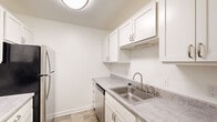 Located at 4172 Pine Creek Rd SW in Grandville, Michigan, this one-bedroom, one-bathroom residence offers a well-organized single-floor layout designed for comfortable everyday living. The galley-style kitchen is bright and functional, featuring white shaker cabinetry, light gray laminate countertops, wood-look luxury vinyl flooring, a stainless steel sink, a dishwasher, a range, and a stainless steel refrigerator — providing ample storage and a clean, modern aesthetic. The spacious living area is carpeted and filled with natural light, anchored by large sliding glass doors that open to a view of lush greenery, creating a seamless indoor-outdoor feel. Baseboard heating runs along the walls throughout the carpeted areas, ensuring year-round warmth. The generously sized primary bedroom features plush carpeting, a walk-in closet with built-in shelving, a large window for natural light, and baseboard heating. The bathroom is finished in a crisp, all-white palette with wood-look tile flooring, a full tub and shower combination with brushed nickel fixtures, a toilet, and a white vanity. Two hallways connect the rooms, providing a logical and easy-to-navigate flow throughout the home. This residence offers a clean, move-in-ready environment in a well-established Grandville neighborhood.