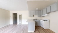 Located at 700 S Lake St in Burbank, CA, this one-bedroom, one-bathroom unit offers a well-organized single-floor layout designed to maximize its compact footprint. The open-concept living and kitchen area serves as the heart of the space, where light wood-style flooring flows seamlessly throughout. The kitchen is a standout feature, equipped with gray shaker-style cabinetry, striking marble-look countertops with a peninsula that adds both prep space and visual appeal, a gas range, a double-basin sink, and an under-cabinet range hood. A wall-mounted heater is conveniently positioned between the kitchen and living area. The living room receives natural light through a large window fitted with vertical blinds and includes a wall-mounted AC unit for climate control. The bedroom offers comfortable carpeting, a generous double sliding-door closet, and a sliding glass door that allows additional natural light to fill the room. The bathroom features a full-size tub and shower combination with clean white surround panels, wood-style flooring, and a vanity with storage. A hallway connects all rooms efficiently, completing this practical and well-appointed layout in a convenient Burbank location.
