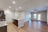 Located at 2747 Kelly Lake Rd in Decatur, GA, this single-story, 4-bedroom, 1-bathroom home offers a well-designed layout with modern finishes throughout. Light wood-style flooring runs continuously across the space, complementing the neutral gray walls and crisp white trim.

The heart of the home is an open-concept living, dining, and kitchen area. The kitchen is outfitted with dark espresso cabinetry, granite-style countertops, stainless steel appliances—including a range, microwave, and refrigerator—and a central island with a sink, providing both prep space and a natural gathering point. Recessed lighting illuminates the area, while the adjacent living room features a ceiling fan and access to natural light through windows and a glass door.

A hallway connects the common areas to the four bedrooms, each finished with the same wood-style flooring and equipped with ceiling fans. The primary bedroom offers generous proportions and direct access to the shared bathroom. The bathroom features a dark vanity with granite countertops, a tub-shower combination, and built-in shelving for storage.

Additional practical spaces include a dedicated laundry room with washer and dryer hookups, a utility room, four closets, and an entrance foyer, making this a highly functional and move-in-ready home.
