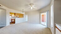 Located at 8120 Mainland Dr in San Antonio, TX, this single-floor, 2-bedroom, 3-bathroom home offers a well-organized layout designed for comfortable everyday living. The open-concept living and kitchen area serves as the heart of the home, with plush carpeting underfoot, a ceiling fan overhead, and a pendant light fixture accentuating the kitchen pass-through. Sliding glass doors lead directly to a private patio, filling the living space with natural light and providing easy outdoor access. The galley-style kitchen features white cabinetry with warm wood trim accents, a double sink, electric range, and durable wood-look flooring. A built-in shelving nook with lower cabinet storage adds a distinctive architectural touch to the main living area. Both bedrooms are carpeted and include ceiling fans, with the primary bedroom benefiting from its own sliding door access to the patio. Each bathroom is cleanly appointed with tub-shower combinations, vanity storage, and wood-look flooring. A dedicated laundry area with washer and dryer hookups adds everyday convenience. Four closets throughout the home ensure ample storage, completing this practical and well-appointed residence.
