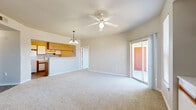 Located at 8120 Mainland Dr in San Antonio, TX, this single-floor, 2-bedroom, 3-bathroom home offers a well-organized layout designed for comfortable everyday living. The open-concept living and kitchen area serves as the heart of the home, with plush carpeting underfoot, a ceiling fan overhead, and a pendant light fixture accentuating the kitchen pass-through. Sliding glass doors lead directly to a private patio, filling the living space with natural light and providing easy outdoor access. The galley-style kitchen features white cabinetry with warm wood trim accents, a double sink, electric range, and durable wood-look flooring. A built-in shelving nook with lower cabinet storage adds a distinctive architectural touch to the main living area. Both bedrooms are carpeted and include ceiling fans, with the primary bedroom benefiting from its own sliding door access to the patio. Each bathroom is cleanly appointed with tub-shower combinations, vanity storage, and wood-look flooring. A dedicated laundry area with washer and dryer hookups adds everyday convenience. Four closets throughout the home ensure ample storage, completing this practical and well-appointed residence.
