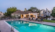 This three-story, 4-bedroom, 4-bathroom home offers 1,650 square feet of thoughtfully distributed living space across its floors, measuring 370, 530, and 750 square feet respectively. Warm hardwood flooring flows consistently throughout the home, complemented by neutral gray walls and white trim. The living room is a standout space, featuring soaring vaulted ceilings, a classic brick fireplace, abundant natural light from large windows, and direct outdoor access via a sliding glass door. The kitchen is well-appointed with gray shaker-style cabinetry, stainless steel appliances including a refrigerator, range, microwave, and dishwasher, white countertops, and a herringbone tile backsplash. The primary bedroom spans 170 square feet, showcasing vaulted ceilings, a walk-in closet, and an en-suite bathroom. Additional bedrooms also feature vaulted or high ceilings, closets, and arched accent windows that bring in natural light. The four bathrooms are finished with gray vanities, white countertops, and clean tile shower surrounds. Three staircases and three hallways connect the multi-level layout efficiently. A dedicated closet on the main level provides additional storage.