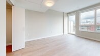 This compact yet efficiently designed 310 square foot studio apartment in Vancouver offers a modern living experience. The space is thoughtfully laid out, maximizing functionality within its single-floor layout. The kitchen is a standout feature, boasting a clean, contemporary design with two-tone cabinetry in white and gray. It's equipped with stainless steel appliances, including a built-in microwave and oven, and features a stylish backsplash and ample counter space.

The bathroom continues the modern aesthetic with a neutral color palette, featuring a spacious vanity with a large mirror, a white countertop, and a shower-tub combination. Gray tile flooring adds a touch of sophistication.

The main living area is bright and airy, with light-colored walls and wood-look flooring that extends throughout the apartment. A large window allows natural light to flood the space and offers impressive city views. The room is versatile, easily accommodating both living and sleeping areas.

High ceilings and recessed lighting contribute to the sense of spaciousness, while the overall design maintains a clean, minimalist feel. This studio apartment efficiently combines style and functionality, making the most of its 310 square feet to create a comfortable urban living space.
