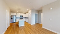 Located on International Drive in Orlando, FL, this well-appointed three-bedroom, three-bathroom residence offers a thoughtfully designed single-floor layout with a clean, modern aesthetic throughout. The open-concept kitchen and living area serves as the heart of the home, showcasing warm light wood flooring, recessed lighting, and a seamless flow between spaces. The kitchen is a standout feature, equipped with crisp white cabinetry — including glass-front upper cabinets — a subway tile backsplash, stainless steel appliances, and a central island with a built-in sink, pendant lighting above, and generous counter space ideal for both cooking and entertaining. The bedrooms are carpeted for comfort, with natural light filtering in through window blinds. The generously sized primary bedroom connects to a well-appointed en-suite bathroom featuring a dual-sink vanity with white cabinetry, quartz countertops, and framed mirrors. Four closets, including a spacious walk-in fitted with wire shelving on multiple levels, provide ample storage throughout. The neutral color palette of soft grays and warm beiges creates a bright, cohesive ambiance that carries through every room, making this a welcoming and functional Orlando residence.