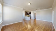 Located at 5565 Mansions Bluffs in San Antonio, Texas, this two-story, two-bedroom, two-bathroom home offers a well-designed layout across two levels. The main living floor is generously proportioned, featuring rich hardwood-style flooring that runs throughout the open-concept kitchen and living areas. The kitchen is a standout, equipped with dark espresso cabinetry, granite countertops, a tile backsplash, and a full suite of stainless steel appliances including a range, built-in microwave, dishwasher, and refrigerator. A kitchen island provides additional prep and seating space. Multiple windows along the living area allow natural light to fill the space, complemented by crown molding and track lighting. A carpeted staircase with a wood handrail connects the floors. The primary bedroom is a comfortable retreat featuring hardwood-style floors, crown molding, and access to a private bathroom with a soaking tub and tile surround. A walk-in closet with built-in shelving and hanging rods adds practical storage. The second bedroom is bright, with a large window and its own closet. Additional highlights include a dedicated laundry area, pantry, patio, and an attached two-car garage with an automatic opener and a window for natural light.