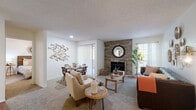 This single-floor residence offers a thoughtfully arranged layout that balances comfort and functionality throughout. The living room serves as the heart of the home, anchored by a striking floor-to-ceiling stone fireplace wall that adds warmth and character. Soft carpeting, multiple windows with vertical blinds, and a textured ceiling contribute to a cozy yet inviting atmosphere, with natural light filtering in from several directions.

Adjacent to the living area, the dining space provides a dedicated area for meals, accented by a decorative geometric wall piece and easy access to a sliding glass door that opens to the outdoors. A breakfast bar connects the living zone to the kitchen, which features warm wood cabinetry, laminate countertops, hardwood-style flooring, and white appliances including a refrigerator, electric range, and over-the-range microwave. A window above the counter brings in additional natural light.

The residence includes two bedrooms, each finished with plush carpeting and ceiling fans. One bedroom benefits from a generously sized window framing outdoor greenery, while the other offers a cozy, well-proportioned retreat. The bathroom features a wood-toned vanity with a marble-style countertop, a tub-shower combination, and speckled tile flooring, providing a clean and practical space.