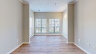 Located at 5500 Oakley Industrial Blvd in South Fulton, GA, this single-story, 2-bedroom, 2-bathroom home offers a thoughtfully designed layout with modern finishes throughout. Warm wood-look flooring flows seamlessly across the entire living space, complemented by neutral taupe-toned walls and crisp white trim that create a clean, cohesive aesthetic.

The combined kitchen and living area serves as the heart of the home. The kitchen is outfitted with white shaker cabinetry, light gray subway tile backsplash, quartz countertops, stainless steel appliances, and a peninsula with an integrated sink — ideal for both cooking and casual dining. The adjacent living room is bright and airy, featuring large windows that invite abundant natural light and views of the surrounding landscape, along with crown molding that adds a refined architectural touch.

Both bedrooms are generously proportioned, each equipped with a ceiling fan and closet. The primary bedroom is notably spacious, highlighted by a wide window that frames outdoor views. The two bathrooms are finished in a clean, contemporary style with white vanities, light countertops, wood-look flooring, and brushed nickel hardware and fixtures. A dedicated utility room accommodates full-size laundry appliances. The hallway connects all rooms efficiently, completing a functional and comfortable floor plan.