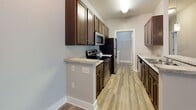 Located at 2320 Margarita Dr in Myrtle Beach, SC, this single-floor unit offers a well-organized layout designed for comfortable everyday living. The open-concept living and dining area is finished with light-toned wood-look flooring and neutral gray walls, creating a clean, cohesive aesthetic throughout. Ceiling fans are installed in the main living spaces, promoting consistent airflow. A wide doorway connects the living area to an additional room that benefits from multiple windows fitted with blinds, allowing for ample natural light.

The galley-style kitchen features rich dark wood cabinetry paired with light granite-style countertops, providing notable storage and prep space. Stainless steel appliances, including a microwave, electric range, and refrigerator, are included. Wood-look flooring continues through the kitchen, which also provides access to a dedicated laundry area equipped with a full-size washer and dryer hookups and wire shelving overhead.

The bedrooms are carpeted for comfort and include ceiling fans and windows with blinds. Each bedroom offers closet access, and the overall layout accommodates two full bathrooms, each featuring a tub-shower combination, granite-style vanity countertops, and wood-look flooring.