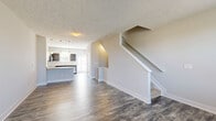 Located at 1206 Robert Rose Drive in Murfreesboro, TN, this three-story townhouse offers a well-organized layout spread across three distinct levels. The entry-level ground floor houses an attached garage with an automatic opener, a convenient entrance, and staircase access to the main living area above.

The primary living floor serves as the social hub of the home, featuring an open-concept layout that seamlessly connects the living room, dining area, and kitchen. Rich hardwood-style flooring runs throughout, complementing the kitchen's dark espresso cabinetry, granite countertops, subway tile backsplash, stainless steel appliances, and a central island with pendant lighting above.

The upper floor is dedicated to private living spaces, including two carpeted bedrooms, three full bathrooms, a dedicated office, a laundry area, and a balcony. The generously sized primary bedroom features dual windows that invite natural light and includes a closet with built-in shelving. The secondary bedroom similarly benefits from natural light and its own closet. The bathrooms are finished with light tile flooring, white vanities, and glass-enclosed showers.

Neutral tones, textured ceilings, and carpeted staircases with white trim detailing carry a clean, cohesive aesthetic throughout the entire home.