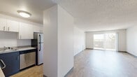 This well-appointed 3-bedroom, 2-bathroom unit at 1251 S Bellaire St in Denver, CO offers a clean, modern living environment spread across a single floor. Light wood-look flooring flows consistently throughout the space, complementing the crisp white walls and contemporary finishes found in every room.

The open-concept kitchen is thoughtfully designed with two-tone cabinetry featuring white upper cabinets and dark lower cabinets, gray countertops, and a full suite of stainless steel appliances including a refrigerator, dishwasher, and electric range. The kitchen connects seamlessly to the combined living and dining area, which is bathed in natural light from a sliding glass door that opens to an outdoor balcony with open views.

Three well-proportioned bedrooms provide ample personal space, each featuring wood-look flooring, neutral walls, and textured ceilings. The generously sized primary bedroom includes its own closet with built-in shelving and hanging rods. Two bathrooms serve the unit, one featuring a dark-cabinet vanity with a wide mirror and stone-look countertop, and the other with a tiled tub-shower combination. Three total closets ensure abundant storage throughout. The unit's clean, neutral palette and functional layout make it a practical and comfortable Denver residence.