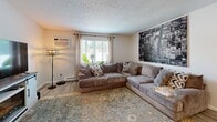 Located at 2011 3rd Ave SE in Aberdeen, South Dakota, this single-floor, 2-bedroom, 1-bathroom unit offers a thoughtfully designed layout that maximizes its compact footprint. The open-concept living, dining, and kitchen area forms the heart of the home, creating a seamless flow between spaces. The kitchen is a standout feature, equipped with crisp white shaker cabinets, granite-look countertops, stainless steel appliances including a refrigerator, electric range, and over-the-range microwave, all set atop light wood-style luxury vinyl plank flooring. The living area provides a comfortable gathering space anchored by a stylish electric fireplace media console, with natural light streaming in through large windows. The primary bedroom offers a well-sized closet and a natural light-filled window, while both bedrooms feature the same light flooring and a clean, neutral palette. The bathroom includes a tiled tub-and-shower combo with floor-to-ceiling tile surround. With three closets providing ample storage and a connecting hallway, this unit delivers practical, move-in-ready living in a clean, updated interior.