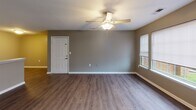 Located at 100 Laurel Pointe Cir in Salisbury, NC, this single-floor residence offers a practical and comfortable layout designed for everyday living. The main living area features durable wood-look flooring and is brightened by natural light streaming through windows fitted with blinds. A ceiling fan overhead adds both style and function to the space. The kitchen is well-equipped with white cabinetry, a black appliance suite including a refrigerator and electric range, light countertops, and a pantry closet for added storage. An adjacent dining or flex area with matching flooring connects seamlessly to the rest of the home. The bedrooms are carpeted in neutral tones and painted in warm gray hues, providing a calm and restful atmosphere. One bedroom features a pass-through to a connected bathroom, enhancing convenience. The bathrooms include tub-shower combinations, wood-look flooring, vanities with mirrors, and one bathroom offers additional built-in shelving for storage. Throughout the home, consistent neutral gray wall tones and white trim create a cohesive, clean aesthetic. The floor plan, visible in the dollhouse view, reveals an efficient and well-organized single-level layout suitable for a variety of living arrangements.