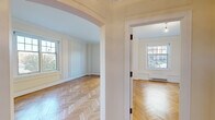 Located at 925 E Wells St in Milwaukee's vibrant East Side, this well-appointed 3-bedroom, 2-bathroom residence showcases a thoughtful blend of classic architectural character and modern updates across a single floor. Striking herringbone-patterned hardwood floors run throughout every room, lending a refined, timeless quality to the entire space.

The spacious living room features crown molding, decorative wall paneling, and generous natural light, opening through an elegant arched doorway into the adjacent rooms. The primary bedroom is notably expansive, with multiple large windows framing views of the surrounding neighborhood streetscape and baseboard heating beneath each sill. The additional bedrooms are well-proportioned, each continuing the herringbone flooring and classic millwork details.

The kitchen is outfitted with white shaker-style cabinetry, dark granite countertops, a classic subway tile backsplash, and stainless steel appliances including a gas range, over-the-range microwave, and dishwasher. Both bathrooms maintain a cohesive vintage aesthetic, featuring white subway tile walls with black accent borders, classic penny tile floors, pedestal sinks, and tub-shower combinations. Two hallways connect the rooms efficiently, completing a practical and characterful floor plan.