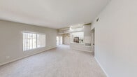 Located at 7401 W Washington Ave in Las Vegas, NV, this 2-bedroom, 2-bathroom residence offers a well-designed single-floor layout with a bright, neutral color palette throughout. The open-concept living area is generously proportioned, featuring plush carpeting, a ceiling fan, and large windows with vertical blinds that allow abundant natural light to fill the space. A pass-through connects the living area to the kitchen, which is outfitted with white shaker cabinetry, sleek white quartz countertops, a classic subway tile backsplash, stainless steel appliances including a gas range with over-the-range microwave, and black hardware accents. The spacious primary bedroom includes a ceiling fan, carpeted flooring, and access to a dedicated bathroom featuring a wide white vanity, quartz countertop, undermount sink, and a large mirror with modern lighting. The second bedroom is well-sized with a window offering natural light and plush carpet. The second bathroom mirrors the clean, updated finishes found throughout the home. A hallway connects the rooms efficiently, and two closets provide ample storage. The overall ambiance is clean, modern, and move-in ready.