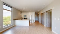 Located at 211 W Mineral St in Milwaukee, WI, this thoughtfully designed 2-bedroom, 1-bathroom residence offers a clean, contemporary aesthetic throughout its efficiently planned single-floor layout. Light wood-tone flooring flows continuously through the open living areas, creating a bright and cohesive atmosphere.

The kitchen is a standout feature, showcasing white cabinetry extending to the ceiling, granite countertops, stainless steel appliances including a refrigerator, microwave, and range, and a peninsula with pendant lighting overhead — ideal for both cooking and casual dining. The open layout connects the kitchen seamlessly to the living area, which is bathed in natural light and opens to a private balcony through large sliding glass doors, offering views of the surrounding Milwaukee neighborhood.

Both bedrooms feature light wood flooring, neutral tones, and wall-mounted ductless HVAC units for individual climate control. The primary bedroom benefits from expansive windows with sweeping outdoor views, while the second bedroom includes access to a dedicated closet. The full bathroom is finished with a granite-topped floating vanity, white cabinetry, and matching wood-tone flooring. Additional conveniences include two closets and an in-unit laundry area, rounding out this modern, move-in-ready residence.