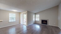 This single-floor residence offers a thoughtfully designed layout that balances open communal spaces with comfortable private areas. The living room serves as the heart of the home, featuring rich wood-look flooring, a tile-surround fireplace, and multiple windows that fill the space with natural light. A sliding glass door leads to a private balcony, extending the living area outdoors. The open-concept design connects the living room seamlessly to the dining area and kitchen, creating an inviting flow throughout.

The kitchen is outfitted with stainless steel appliances, including an electric range and over-the-range microwave, complemented by white cabinetry with brushed nickel hardware and granite-style countertops. A pass-through counter connects the kitchen to the dining and living areas, enhancing the open feel.

The bedrooms are carpeted for warmth and comfort, each featuring ceiling fans and ample natural light. Closets with louvered bifold doors provide generous storage. The bathrooms are finished with granite-style countertops, white cabinetry, and wood-look flooring. One bathroom includes a walk-in shower, while the other features a tub-shower combination. Textured ceilings and neutral wall tones throughout give the space a clean, cohesive aesthetic.
