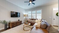 Located at 5833 Evans Farm Dr in Lewis Center, Ohio, this two-story home offers a thoughtfully designed layout across two well-proportioned floors. The main level features an open-concept dining room and kitchen combination that serves as the heart of the home. The kitchen is outfitted with white shaker cabinetry, dark countertops, stainless steel appliances, and a large center island with seating, all illuminated by stylish pendant lighting. The adjacent dining area enjoys abundant natural light through large windows and is anchored by an elegant chandelier. The living room is bright and inviting, with a ceiling fan, wide windows, and warm hardwood-style flooring throughout. A convenient half bath completes the main level. Upstairs, the spacious primary bedroom features plush carpeting and generous natural light. All three bedrooms are well-sized and include dedicated closets. The bathrooms are finished with white cabinetry, dark countertops, and modern black hardware accents. With six closets, a dedicated laundry room, and a utility room, storage and functionality are prioritized throughout. A private patio accessible from the exterior offers outdoor living space. The home's brick exterior, crown molding details, and cohesive neutral palette lend a refined, move-in-ready aesthetic.