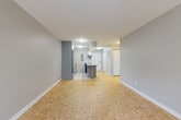 Located on the 17th floor at 1436 MacKay in downtown Montréal, this well-appointed one-bedroom, one-bathroom unit offers a thoughtfully designed layout across a single floor. The open-concept living and dining area is finished with classic light parquet flooring in a herringbone pattern, lending warmth to the neutral grey walls throughout. Large windows and a private balcony allow natural light to fill the living space, creating a bright and airy atmosphere.

The kitchen is efficiently designed with white cabinetry, white tile flooring, a stainless steel refrigerator, and a built-in range with an overhead hood vent. A peninsula with a grey countertop extends into the living area, offering additional prep space and a casual seating option. The kitchen flows naturally into the main living area, making the overall space feel open and connected.

The bedroom is a comfortable size, featuring the same parquet flooring, a double closet, and a window that brings in natural light. An additional closet in the unit provides generous storage. The full bathroom is clean and bright, finished in white tile with a full-size bathtub, toilet, and a vanity with mirror. A hallway connects the rooms, completing a practical and cohesive floor plan suited for comfortable urban living.