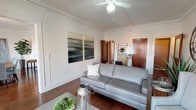 This single-floor residence blends classic architectural character with modern updates throughout its thoughtfully designed layout. The living room serves as a welcoming focal point, anchored by a white-painted brick fireplace with a wood mantle and rich hardwood floors that extend throughout the main living areas. A glazed dark-wood entry door admits natural light, and access to a balcony brings in additional brightness and open street views.

The dining area is defined by a bank of large windows overlooking the balcony, flooding the space with natural light. Crown molding and a sleek linear pendant light add refined detail to the room.

The kitchen features white shaker cabinetry, granite-look countertops, a subway tile backsplash, stainless steel appliances including a French door refrigerator, electric range, built-in microwave, and dishwasher, alongside durable wood-look flooring.

The bedrooms offer hardwood floors, dark-stained wood trim, and transom window details. One bedroom opens to balcony views, while another features a tufted upholstered headboard wall and warm, intimate ambiance.

The bathroom presents a clean, bright design with white cabinetry, granite countertops, subway tile accents, a window for natural light, and a chrome towel bar.