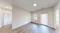 This single-floor, 3-bedroom, 3-bathroom residence offers a clean, modern design with a practical and comfortable layout. The open-concept living and kitchen area forms the heart of the home, featuring warm wood-look luxury vinyl plank flooring, recessed lighting, and a bright, neutral color palette throughout. The kitchen is well-equipped with gray shaker-style cabinetry, granite-look countertops, and a full suite of stainless steel appliances including a refrigerator, gas range, microwave, and dishwasher — all set against a crisp white backsplash. The living area flows naturally from the kitchen, offering an open and airy feel. The bedrooms are carpeted for comfort, with multiple rooms featuring windows that bring in natural light and outdoor views. The primary bedroom provides a comfortable retreat with its own dedicated bathroom. All three bathrooms are finished with gray vanities, granite-topped counters, and tub/shower combinations with built-in shelving. A dedicated laundry area houses a stacked full-size washer and dryer. Four closets distributed throughout the unit offer ample storage. The space presents a cohesive, move-in-ready environment with thoughtful finishes and a well-organized floor plan.