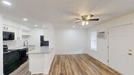Located at 852 Malabu Dr in Lexington, Kentucky, this efficiently designed 1-bedroom, 1-bathroom unit offers a thoughtful single-floor layout. Wood-look plank flooring runs throughout the living areas and bedroom, providing a warm, cohesive aesthetic. The open living room is bright and airy, illuminated by recessed lighting and a ceiling fan with light fixture, and features a wall-mounted air conditioning unit alongside windows dressed with blinds for light control. The kitchen is positioned adjacent to the living area and features white cabinetry, a classic subway tile backsplash, granite-look countertops, a breakfast bar peninsula, and black appliances including a range and over-the-range microwave. A second area off the kitchen offers additional dining or flex space with its own ceiling fan and recessed lighting. The bedroom is a comfortable size, enhanced by a ceiling fan, hardwood-style flooring, vertical blind-covered sliding door access, and a closet. The bathroom presents a clean, all-white design with a tub-shower combination, tile flooring, and brushed nickel hardware. Two closets and a utility room round out the functional layout, offering practical storage throughout.
