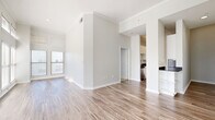 Located on McKinney Avenue in Dallas's vibrant Uptown neighborhood, this 2-bedroom, 3-bathroom residence offers a bright and modern living experience. The open-concept living room and kitchen area is anchored by wood-look flooring, crown molding, and soaring ceilings that amplify the sense of space. Large windows flood the interior with natural light and frame views of the surrounding cityscape. The kitchen is well-appointed with white shaker cabinetry, dark granite countertops, a classic subway tile backsplash, and a full suite of stainless steel appliances. Three hallways connect the layout efficiently, lending the floor plan a clean, organized flow. The two bedrooms feature plush carpeting and impressively tall ceilings with generous window arrangements that continue the home's bright aesthetic. Both bedrooms are served by closet storage, and the primary bedroom offers a comfortable, well-proportioned retreat. The three bathrooms include soaking tubs finished with warm beige tile surrounds and chrome fixtures, providing a clean and functional design. A dedicated closet adds additional storage throughout. The overall palette of soft whites and neutral tones creates a calm, contemporary ambiance throughout the entire residence.