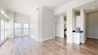 Located on McKinney Avenue in Dallas's vibrant Uptown neighborhood, this 2-bedroom, 3-bathroom residence offers a bright and modern living experience. The open-concept living room and kitchen area is anchored by wood-look flooring, crown molding, and soaring ceilings that amplify the sense of space. Large windows flood the interior with natural light and frame views of the surrounding cityscape. The kitchen is well-appointed with white shaker cabinetry, dark granite countertops, a classic subway tile backsplash, and a full suite of stainless steel appliances. Three hallways connect the layout efficiently, lending the floor plan a clean, organized flow. The two bedrooms feature plush carpeting and impressively tall ceilings with generous window arrangements that continue the home's bright aesthetic. Both bedrooms are served by closet storage, and the primary bedroom offers a comfortable, well-proportioned retreat. The three bathrooms include soaking tubs finished with warm beige tile surrounds and chrome fixtures, providing a clean and functional design. A dedicated closet adds additional storage throughout. The overall palette of soft whites and neutral tones creates a calm, contemporary ambiance throughout the entire residence.