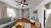 Located in Mobile, Alabama, this two-story home offers a well-organized layout across two floors, providing comfortable living spaces throughout. The main level features hardwood-style flooring in the living and dining areas, where natural light filters through large windows dressed with sheer curtains. The living room offers a relaxed atmosphere with a ceiling fan overhead, while the dining room opens through French doors, enhancing the connection between indoor and outdoor spaces. The kitchen is outfitted with crisp white shaker cabinets, granite-style countertops, a subway tile backsplash, and stainless steel appliances including a dishwasher and range. Light tile flooring extends through the kitchen and dining areas, creating a cohesive feel on the main level. A versatile secondary room on the lower floor serves well as a home office or flex space, featuring tile flooring and open sightlines to adjacent hallways. Upstairs, both bedrooms are carpeted and equipped with ceiling fans. The spacious primary bedroom benefits from multiple windows that bring in ample natural light. Each bathroom is cleanly finished with gray cabinetry, white countertops, and tile flooring. Closets provide practical storage, including a walk-in with wire shelving. The home presents a neutral, move-in-ready aesthetic throughout.