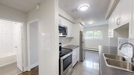 Located on Marland Avenue in Oshawa, Ontario, this well-appointed one-bedroom, one-bathroom unit offers a thoughtfully organized layout across a single floor. The living room is a highlight of the space, featuring rich parquet hardwood flooring, crisp white walls, and a sliding glass door that opens to a private balcony with pleasant outdoor views of surrounding greenery. Baseboard heating runs along the perimeter, ensuring year-round comfort.

The kitchen is modern and functional, outfitted with white cabinetry, subway tile backsplash, dark countertops, and a full suite of stainless steel appliances including a fridge, stove, and over-the-range microwave. Light tile flooring and a window allow natural light to brighten the space. A peninsula counter creates a practical divide between the kitchen and the adjacent living area.

The bedroom is a comfortable, well-sized room with the same classic parquet flooring, a window overlooking the outdoors, baseboard heating, and a mirrored sliding closet that adds depth and light to the room.

The bathroom is clean and bright, featuring white subway tile surrounding a full soaker tub and shower, a pedestal-style sink with a dark wood vanity, and tiled flooring, creating a fresh and timeless aesthetic throughout.