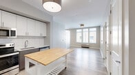 Located at 249 W Side Ave in Jersey City, NJ, this well-appointed one-bedroom, one-bathroom residence offers a thoughtfully designed single-floor layout with contemporary finishes throughout. Light wood-tone flooring flows consistently across the living areas, creating a warm and cohesive aesthetic.

The kitchen is a standout feature, showcasing white upper cabinetry, dark lower cabinets, and a classic white subway tile backsplash. A full suite of stainless steel appliances — including a French door refrigerator, electric range with microwave above, and dishwasher — provides modern functionality. A movable kitchen island with a butcher block top adds flexible prep and dining space.

The living area is bright and open, benefiting from large windows that invite natural light. A distinctive sliding panel door adds a modern architectural element while offering room division flexibility.

The bedroom is a comfortable, well-proportioned space featuring dual windows with views of the surrounding neighborhood and light wood flooring that continues from the main living area.

The bathroom is clean and efficiently laid out, with large-format neutral floor tiles, a white vanity with sink, a wall-mounted medicine cabinet, and overhead vanity lighting. The overall palette of soft grays and whites throughout the unit contributes to a calm, modern ambiance.