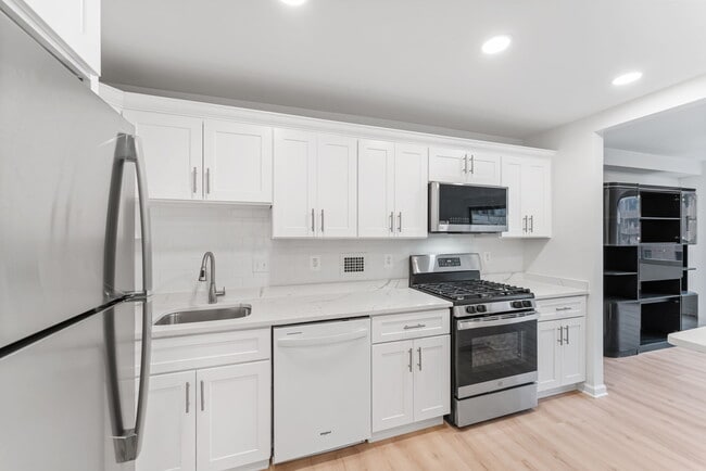 Kitchen has new white wood cabinetry & quartz counters! - 4515 Willard Ave