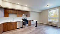 Located at 375 Osprey Ln in Independence, Oregon, this thoughtfully designed one-bedroom, one-bathroom unit offers an efficient and modern living experience across a single floor. The open-concept layout seamlessly combines the living room, dining area, and kitchen into one cohesive space, making excellent use of every square foot. Light wood-look flooring runs throughout, complementing the neutral warm-beige walls and recessed lighting overhead.

The kitchen is a standout feature, outfitted with rich warm-toned wood cabinetry, white quartz countertops, and a full suite of stainless steel appliances — including a side-by-side refrigerator with ice maker, electric range with range hood, and dishwasher. A built-in bar-height counter extends from the kitchen, providing a practical dining or workspace area.

The bedroom is a comfortable, well-proportioned retreat featuring light-filled windows with exterior views and a sliding closet for storage. An additional closet provides extra organizational space. The full bathroom features tile flooring, a soaking tub with shower combination, a wood-trimmed vanity with white countertop, and recessed lighting.

A dedicated laundry room with a full-size washer and dryer adds everyday convenience. Clean lines, contemporary finishes, and a functional floor plan define this well-appointed Independence residence.
