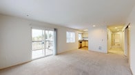 This single-floor residence offers a clean, functional layout with a bright and open design throughout. The spacious living area is anchored by soft wall-to-wall carpeting and filled with natural light streaming through large windows and a sliding glass door that opens onto a private balcony, offering pleasant outdoor views of the surrounding neighborhood and greenery. The open-plan layout connects the living space seamlessly to the kitchen, which features light maple cabinetry, granite-style countertops, hardwood-style flooring, stainless steel appliances including a range and refrigerator, and ample storage and counter space. The bedrooms are generously proportioned, each finished with plush carpeting, sliding closets, and windows that bring in natural light. One bedroom benefits from a baseboard heater and a wide window framing a scenic tree-lined view. The bathroom is well-appointed with hardwood-style flooring, a vanity featuring granite-style countertops and light maple cabinetry, and a shower-tub combination. Throughout the residence, neutral tones and clean lines create a calm, welcoming ambiance that is both practical and inviting.