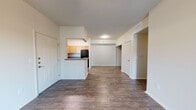 This well-designed single-story home offers four bedrooms and two bathrooms across a thoughtfully laid-out floor plan. The open-concept living and dining area is anchored by rich wood-style flooring and crisp white walls, creating a clean, neutral canvas throughout. A central hallway connects the main living spaces to the private bedroom wing, ensuring a practical and logical flow.

The kitchen is efficiently designed in a U-shaped configuration, featuring light maple cabinetry, dark granite-style countertops, and black appliances including a range with overhead ventilation and a full-size refrigerator. A peninsula counter opens toward the living area, enhancing the sense of connectivity between spaces.

The bedrooms are carpeted for comfort, with several rooms offering generous closet space — including double sliding-door closets and a walk-in closet in one of the rooms — providing ample storage throughout. The primary bedroom offers a comfortable footprint suitable for a full furniture arrangement.

Both bathrooms are finished consistently with wood-style flooring, light wood vanity cabinetry, dark countertops, and tub-shower combinations. One bathroom features an extended vanity with additional counter space. The home's neutral palette and practical finishes make it a versatile and move-in ready space.