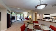 Located at 8185 Summerset Dr in Colorado Springs, Colorado, this single-story residence offers a well-organized layout designed for comfortable everyday living. The open-concept living and dining area serves as the heart of the home, featuring plush carpeting, a textured ceiling, and a corner fireplace that anchors the living space. A built-in shelving unit adds both function and visual interest, while a sliding glass door floods the room with natural light and provides direct access to a private outdoor patio with views of mature trees. The dining area accommodates a full-sized table and is positioned adjacent to a pass-through that connects to the kitchen.

The galley-style kitchen is efficiently designed with white cabinetry, dark countertops, hardwood-style flooring, and black appliances including a range and refrigerator, along with a double basin sink. Two carpeted bedrooms offer comfortable retreats, each with windows that bring in natural light. One bedroom features direct access to an in-unit laundry area. Two full bathrooms are finished with hardwood-style floors, clean white vanities, and tub-shower combinations. The overall ambiance throughout the space is warm and neutral, with a cohesive, move-in-ready aesthetic.