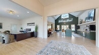The Hawthorne at Kennesaw leasing office at 4045 George Busbee Pkwy NW is a thoughtfully designed, single-story community space that blends professional functionality with a warm, residential aesthetic. Light wood-look flooring flows throughout, tying together each distinct area cohesively.

Visitors are welcomed into a spacious reception area featuring a large dark wood desk, comfortable seating, and the Hawthorne at Kennesaw branding prominently displayed on the wall. The space opens into two generously sized living and lounge areas. The main lounge showcases soaring vaulted ceilings, an arched window allowing abundant natural light, a modern linear fireplace set against a deep green accent wall, open wood shelving, and a contemporary chandelier — creating an inviting, upscale atmosphere.

The kitchen area is equally impressive, featuring rich forest-green cabinetry with gold hardware, a bold geometric tile backsplash, quartz countertops, stainless steel appliances, and direct access to the outdoor pool area.

Two private offices provide quiet, professional spaces for leasing consultations, each appointed with dark wood desks, plush seating, and large windows overlooking lush greenery. Crown molding and curated décor throughout reinforce the polished, welcoming character of the entire office.