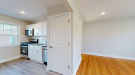 Located at 33 Fair Lawn Ave, this 2-bedroom, 1-bathroom residence offers a thoughtfully arranged single-floor layout that makes excellent use of its space. Warm-toned hardwood floors flow consistently throughout, lending a cohesive and inviting character to every room.

The kitchen is fully updated with crisp white shaker cabinets, granite countertops, a subway tile backsplash, and stainless steel appliances including a gas range, microwave, and dishwasher. A large window floods the adjoining dining area with natural light, while a classic cast-iron radiator adds a charming, functional detail.

The spacious primary bedroom features dual windows that frame pleasant outdoor views and allow abundant natural light to fill the room. A wall-mounted air conditioning unit and radiator provide year-round comfort. The second bedroom is comfortably sized and sun-drenched, with clean finishes throughout.

The bathroom is neatly finished with white subway tile surrounding the tub-shower combo, a classic vanity with mirrored medicine cabinet, tile flooring, and a bright window. A connecting hallway with staircase railing detail and a well-organized closet complete the layout. The overall ambiance is clean, bright, and move-in ready.