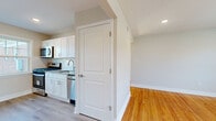 Located at 33 Fair Lawn Ave, this 2-bedroom, 1-bathroom residence offers a thoughtfully arranged single-floor layout that makes excellent use of its space. Warm-toned hardwood floors flow consistently throughout, lending a cohesive and inviting character to every room.

The kitchen is fully updated with crisp white shaker cabinets, granite countertops, a subway tile backsplash, and stainless steel appliances including a gas range, microwave, and dishwasher. A large window floods the adjoining dining area with natural light, while a classic cast-iron radiator adds a charming, functional detail.

The spacious primary bedroom features dual windows that frame pleasant outdoor views and allow abundant natural light to fill the room. A wall-mounted air conditioning unit and radiator provide year-round comfort. The second bedroom is comfortably sized and sun-drenched, with clean finishes throughout.

The bathroom is neatly finished with white subway tile surrounding the tub-shower combo, a classic vanity with mirrored medicine cabinet, tile flooring, and a bright window. A connecting hallway with staircase railing detail and a well-organized closet complete the layout. The overall ambiance is clean, bright, and move-in ready.
