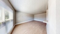 This single-floor space offers a well-designed layout that balances character with modern updates throughout. The living area serves as a standout feature, showcasing a full whitewashed brick accent wall that adds texture and visual interest against neutral-toned walls and light wood-look flooring that flows seamlessly throughout the unit. Ceiling fans are present in multiple rooms, providing both function and comfort.

The kitchen is thoughtfully appointed with crisp white cabinetry, granite-look countertops, a tile backsplash, and a full suite of stainless steel appliances including a range, microwave, and dishwasher. The layout provides ample workspace and storage for everyday use.

The bedrooms continue the cohesive aesthetic, each featuring the same light wood-look flooring, neutral wall tones, ceiling fans, and windows that allow natural light to filter in. One bedroom also features the signature whitewashed brick accent wall, creating a striking and consistent design thread.

The bathroom is clean and contemporary, featuring a wood-tone vanity with a white basin sink, matte black fixtures, a framed mirror with medicine cabinet, and a full soaking tub with shower. The whitewashed brick detail carries into the bathroom as well, tying the overall design together with a cohesive, modern-rustic aesthetic.