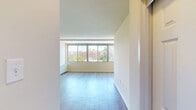 Located at 925 25th St NW in Washington, DC's vibrant West End neighborhood, this well-appointed studio offers a thoughtfully designed single-floor layout. The open living area is characterized by light-toned hardwood flooring that runs throughout, lending the space a clean, contemporary feel. Large windows line one side of the room, inviting an abundance of natural light and framing views of the surrounding urban greenery and cityscape — a standout feature that enhances the overall sense of openness. A built-in wall unit provides climate control directly within the living space.

The kitchen is efficiently integrated into the layout, featuring a peninsula-style counter that separates it from the main living area. It is equipped with essential appliances, including a range and refrigerator, making it fully functional despite its compact footprint.

The bathroom is finished with neutral tile flooring, white wall tile, and a dark-stained wood vanity cabinet topped with a white sink. A large mirror with overhead vanity lighting completes the space, adding brightness and depth. A dedicated closet provides practical storage solutions.

With its clean white walls, natural light, and city views, this studio offers a comfortable and functional urban living experience in one of Washington, DC's most accessible neighborhoods.