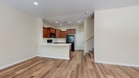 Located in Glendale, Arizona, this two-story, 3-bedroom, 4-bathroom home offers a well-organized layout spread across two floors. The ground floor hosts the combined kitchen and living area, a garage with an automatic opener and water heater, and staircase access to the upper level. The kitchen is outfitted with warm-toned wood cabinetry, light countertops, a stainless steel sink, and black appliances including a range, microwave, dishwasher, and refrigerator, all set atop durable wood-look plank flooring. The upper floor contains all three bedrooms, four bathrooms, a dedicated laundry room, hallways, and a walk-in closet. The primary bedroom is a comfortable size, featuring vaulted ceilings, plush carpet, and a ceiling fan, with an adjacent bathroom and a walk-in closet equipped with built-in shelving and hanging rods. The secondary bedrooms also feature carpet flooring, ceiling fans, and windows that bring in natural light. Bathrooms are finished with wood-look flooring, white tub-shower combinations with tiled surrounds, and warm wood cabinetry accents. The in-unit laundry room includes a full-size washer and dryer with overhead shelving. Throughout the home, neutral tones and consistent finishes create a clean, cohesive aesthetic.