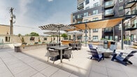 Located at 3250 W 66th St in Edina, Minnesota, this thoughtfully designed outdoor amenity space serves as a central gathering hub within a modern multi-story residential community. The exterior architecture blends warm brick with contemporary corrugated metal paneling and large glass doors, creating a polished, urban aesthetic throughout.

The centerpiece of the space is a resort-style outdoor swimming pool surrounded by a generous pool deck furnished with rows of cushioned chaise lounges, providing ample space for sunbathing and relaxation. Adjacent to the pool, a covered pergola with warm wood detailing and string lighting defines an inviting outdoor lounge area, seamlessly connecting to additional seating zones.

Throughout the courtyard, large-format concrete pavers provide a clean, cohesive foundation. Raised concrete planters filled with ornamental grasses and seasonal plantings add structured greenery and natural texture. Multiple distinct seating areas accommodate a range of social settings, from intimate gatherings around fire features to larger group dining under striped market umbrellas. Outdoor kitchen and grilling stations offer functional entertaining options.

Black metal railings, ramps, and pathways ensure accessible circulation throughout the space. The entire courtyard is framed by the residential building rising above, with private balconies overlooking the amenity level, reinforcing a strong sense of community and place.