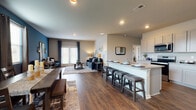 Located at Poplar Road in Newnan, Georgia, this two-story home combines contemporary design with functional living spaces across multiple well-appointed rooms. Rich hardwood-style flooring flows throughout the main level, anchoring an open-concept layout that seamlessly connects the kitchen, dining, and living areas.

The kitchen is outfitted with crisp white shaker cabinetry, granite countertops, stainless steel appliances, and a large island with bar seating — ideal for both everyday meals and entertaining. The adjacent living and dining areas are distinguished by bold teal accent walls and large windows that invite natural light. A welcoming entryway hallway with decorative mirrors leads into the heart of the home.

Bedrooms continue the teal accent palette and feature hardwood-style flooring. A generously sized walk-in closet with wire shelving and a natural light window provides ample storage. The full bathroom includes a soaking tub and tile flooring. A dedicated laundry room with full-size washer and dryer connections, built-in shelving, and light tile floors adds everyday convenience.

The dollhouse view reveals a thoughtfully arranged floor plan with multiple bedrooms, well-defined common areas, and a layout designed for comfort and practicality throughout both levels of the home.