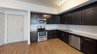 This single-story unit at 8104 Spring Hill Drive offers a thoughtfully designed layout with consistent finishes throughout. The kitchen serves as a standout feature, outfitted with rich, dark espresso-toned cabinetry extending to the ceiling for ample storage. Stainless steel appliances — including a range, microwave, dishwasher, and refrigerator — complement the light-toned countertops, while a decorative tile backsplash adds visual texture. Track lighting illuminates the workspace effectively, and wood-look plank flooring runs throughout, providing a warm, cohesive aesthetic.

The living and bedroom areas are generously proportioned, each featuring the same wood-look flooring, ceiling fans with light fixtures, and large windows dressed with vertical blinds that invite natural light. The neutral wall tones throughout create a clean, versatile backdrop.

The bathrooms are finished with light tile flooring and bright white fixtures. Both feature tub-shower combinations with white tile surrounds and stainless steel grab bars, reflecting an accessibility-conscious design. One bathroom includes a window for natural ventilation. Overall, the unit presents a clean, modern aesthetic with practical finishes suited to everyday living in Spring Hill, Florida.
