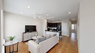 This single-floor residence offers two bedrooms and two bathrooms within a thoughtfully designed open-concept layout. The living area features warm wood-style flooring, recessed lighting, and a ceiling fan, creating a bright and comfortable atmosphere. Large windows along one wall flood the space with natural light and provide views of the surrounding neighborhood, enhancing the open feel of the room.

The kitchen is designed for functionality, featuring dark espresso cabinetry, dark granite countertops, and black appliances including a range, microwave, and refrigerator. A breakfast bar connects the kitchen seamlessly to the living area, making it ideal for both daily use and entertaining.

Both bedrooms are carpeted for comfort and equipped with ceiling fans. Each room benefits from multiple windows that allow ample natural light to filter through. The primary bathroom offers a dual-sink vanity with granite countertops, dark cabinetry, and wood-style flooring, while the second bathroom features neutral tones with clean, modern fixtures.

Throughout the residence, a neutral color palette, recessed lighting, and consistent finishes create a cohesive and contemporary ambiance well-suited for comfortable living.