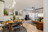 This thoughtfully designed 2-bedroom, 2-bathroom residence offers a comfortable and functional single-floor layout. The open-concept living and dining area features light wood-style flooring, crown molding, and a ceiling fan, creating a bright and inviting atmosphere. Sliding glass doors lead to a private outdoor space, filling the living room with natural light. A stylish pendant light fixture anchors the dining area just off the kitchen.

The kitchen is well-equipped with two-tone cabinetry — light lower cabinets paired with bold dark upper cabinets — complemented by a chevron-patterned tile backsplash, white quartz countertops, and black appliances including a range, microwave, dishwasher, and refrigerator. A pantry provides additional storage.

Both bedrooms are generously sized with plush carpet, ceiling fans, and ample closet space. The primary bedroom features a spacious layout with room for a large bed and dual nightstands. The second bedroom also offers a comfortable footprint with a built-in closet.

Each bathroom is finished with wood-tone vanities, quartz countertops, vessel sinks, matte black fixtures, and large mirrors. An in-unit laundry area with overhead shelving adds everyday convenience. A hallway and dedicated closet complete the efficient floor plan.