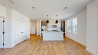 Located at 2600 Roby Corlew Ln in Murfreesboro, TN, this well-designed 2-bedroom, 2-bathroom residence offers a thoughtfully laid-out single-floor plan with contemporary finishes throughout. The heart of the home is an open-concept living, dining, and kitchen area bathed in natural light from large windows. The kitchen is a standout feature, showcasing a central island with a white quartz countertop, dual black pendant lights with gold accents, stainless steel appliances including a French door refrigerator and built-in microwave, and a two-tone cabinet scheme combining white upper cabinets with dark lower cabinetry. Open shelving adds a stylish touch near the dining area. Warm-toned wood-look flooring flows seamlessly throughout the entire residence, complementing the clean white walls and black hardware accents. The primary bedroom is generously sized, featuring a ceiling fan, ample natural light, and access to a well-appointed bathroom with a wood-toned vanity, white countertop, framed mirror, and coordinating black fixtures. A second bedroom offers a ceiling fan and bright windows. One bathroom includes a soaking tub with marble-style tile surround. Additional highlights include multiple closets, a laundry area, a utility room, and a private balcony accessible via a glass-panel door overlooking the surrounding neighborhood.