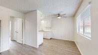 Located at 1450 E Del Mar Ave in Orange, CA, this single-floor, 2-bedroom, 2-bathroom residence offers a clean, functional layout with a bright and neutral aesthetic throughout. Light wood-style flooring runs continuously across the living areas, bedrooms, and hallway, creating a cohesive and easy-to-maintain interior.

The spacious living room is filled with natural light from large windows fitted with horizontal blinds, offering views of the surrounding neighborhood. A ceiling fan with integrated lighting adds comfort, while a wall-mounted AC unit provides climate control. The open layout flows naturally into the combined dining and kitchen area, which is semi-partitioned for a defined yet connected feel.

The galley-style kitchen features white cabinetry with ample storage, light stone countertops, a gas range, a sink, and a built-in dishwasher—all set beneath recessed overhead lighting and a textured ceiling.

The primary bedroom is generously proportioned, with a window that brings in natural light, direct access to a private en-suite bathroom, and a dedicated closet. The en-suite bath includes a vanity with a large mirror, white cabinetry, and a tub/shower combo with glass sliding doors. The second bedroom is similarly bright with outdoor-facing windows and closet access. A second full bathroom with a glass-enclosed shower serves the rest of the unit. A connecting hallway ties all rooms together efficiently.